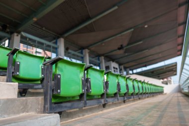 Arenadaki futbol stadyumunda boş plastik stadyum koltukları.