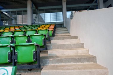 Arenadaki futbol stadyumunda boş plastik stadyum koltukları.