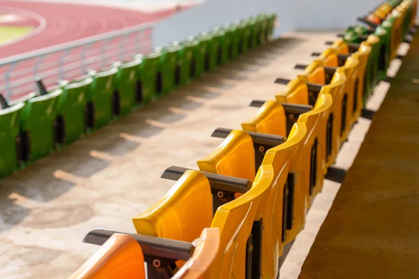 Arenadaki futbol stadyumunda boş plastik stadyum koltukları.