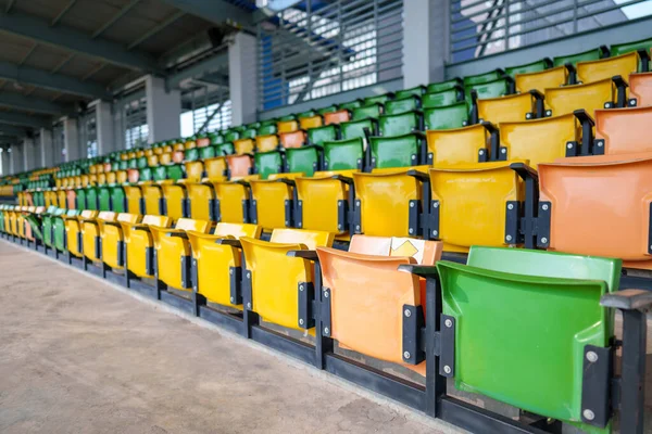 Arenadaki futbol stadyumunda boş plastik stadyum koltukları.