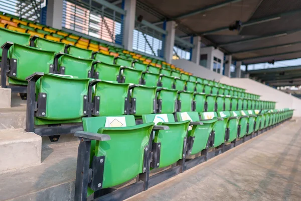 Arenadaki futbol stadyumunda boş plastik stadyum koltukları.