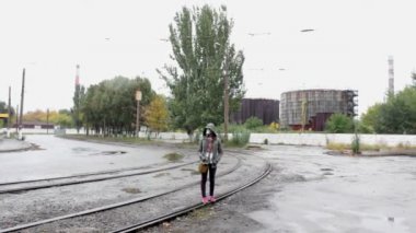 Gaz Maskeli kız raylar üzerinde yürüyor
