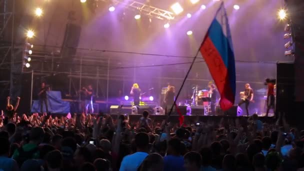 Fãs com bandeira russa na performance ao vivo da banda de rock Bi-2. Desfoque . — Vídeo de Stock