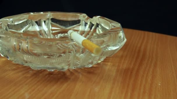 cigarette dans un cendrier en verre 