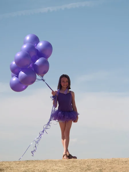 Pretty little girl with baloons in hand — Stock Photo, Image