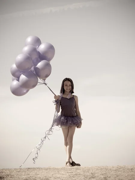 Pretty little girl with baloons in hand — Stock Photo, Image