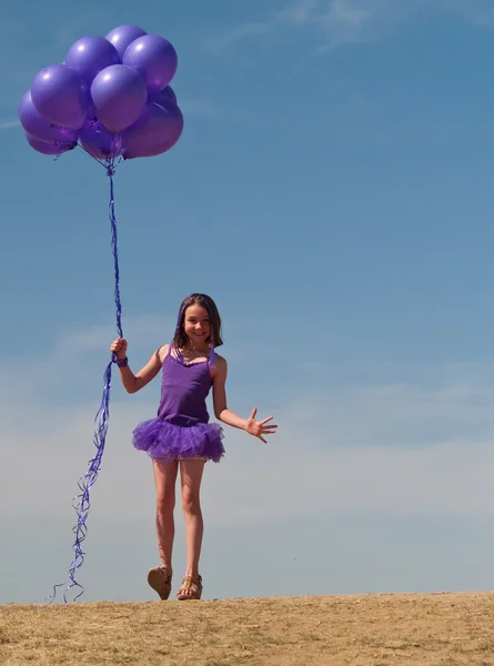 Pretty little girl with baloons in hand — Stock Photo, Image