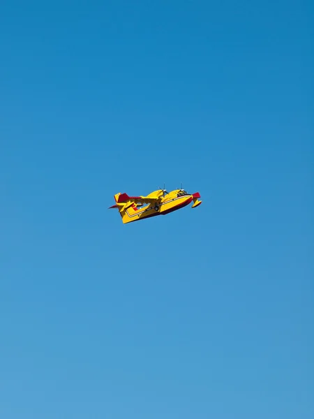 푸른 하늘에 노란색 소방 비행기 — 스톡 사진