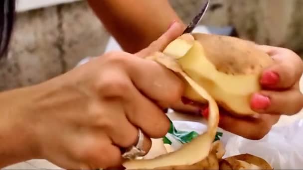 Unga wooman peeling potatis — Stockvideo