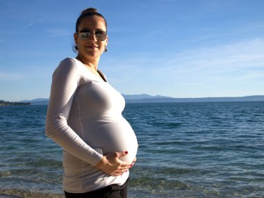 Karnını tutan hamile kadın. 