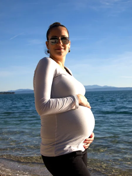 Беременная женщина у моря — стоковое фото