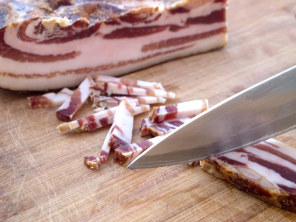 Cutting smoked bacon — Stock Photo, Image