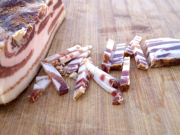 Smoked bacon on wooden board — Stock Photo, Image