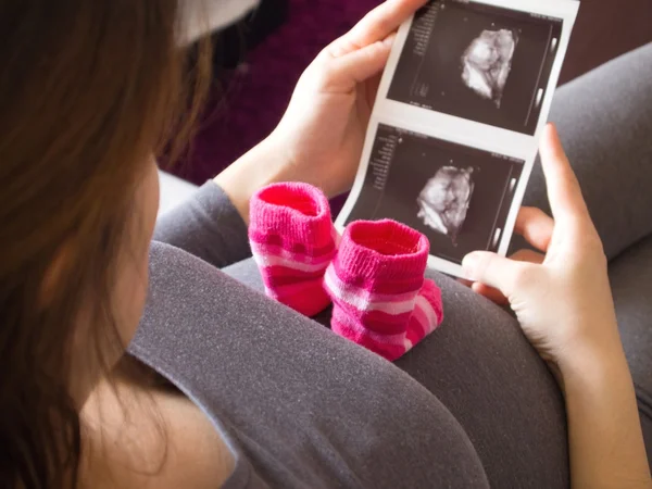 Schwangere sucht Röntgenbild von Baby Stockbild