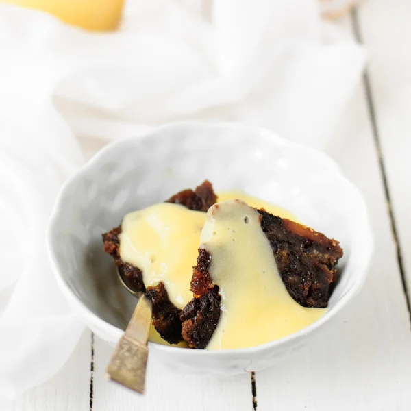 Stukken van plum pudding in een kom met vanille vla, kopie ruimte voor uw tekst — Stockfoto