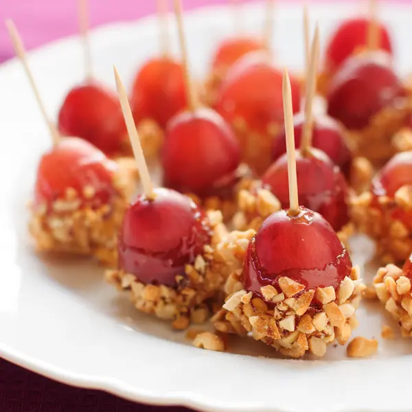 Caramel coated grapes with peanuts — Stock Photo, Image