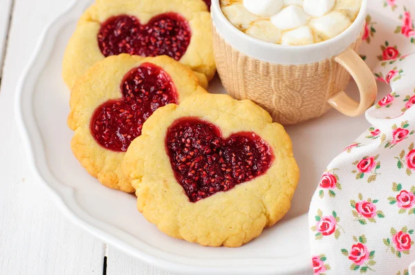 Hausgemachte Plätzchen mit herzförmiger Mitte und einer Tasse heißer Schokolade — Stockfoto