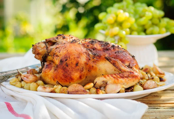 Целая жареная курица с виноградом, чесноком и миндалем — стоковое фото