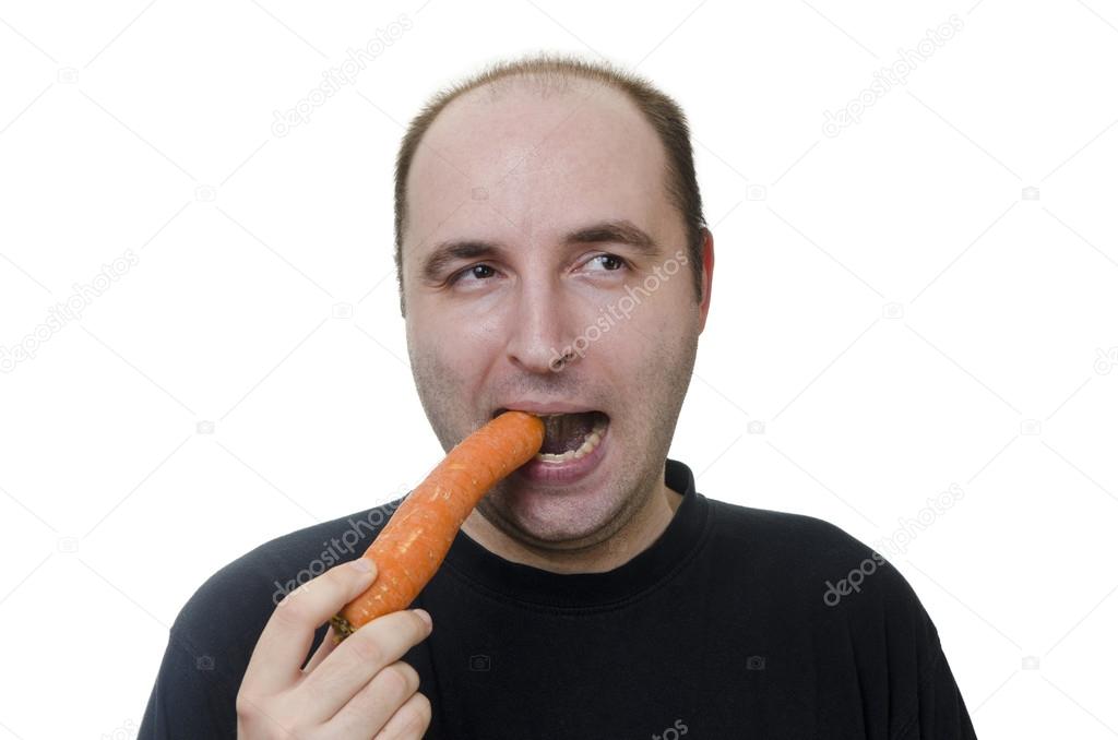Young man eating a carrot on white background