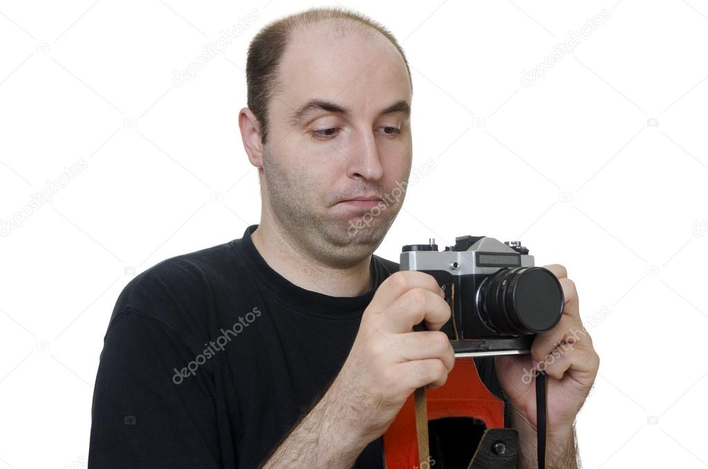Young man holding a vintage camera on white background