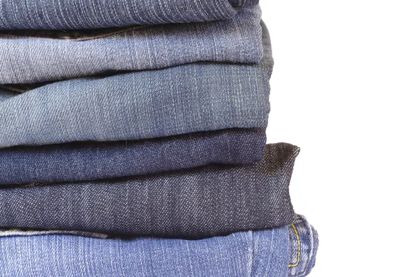 Close up stack of folded jeans on white background — Stock Photo, Image