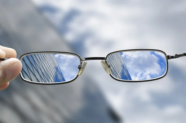 Vision of a glass business building through glasses — Stock Photo, Image