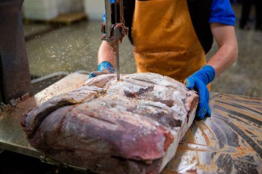 A slaughterhouse worker cut the liver into portions. The concept of sausage and delicatessen production.