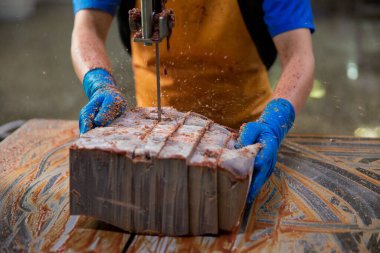 A slaughterhouse worker cut the liver into portions. The concept of sausage and delicatessen production.