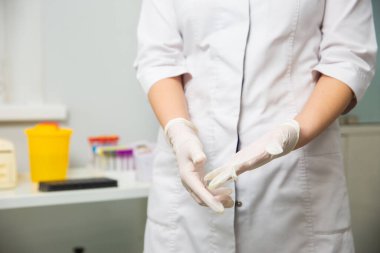 emale doctor puts on disposable gloves