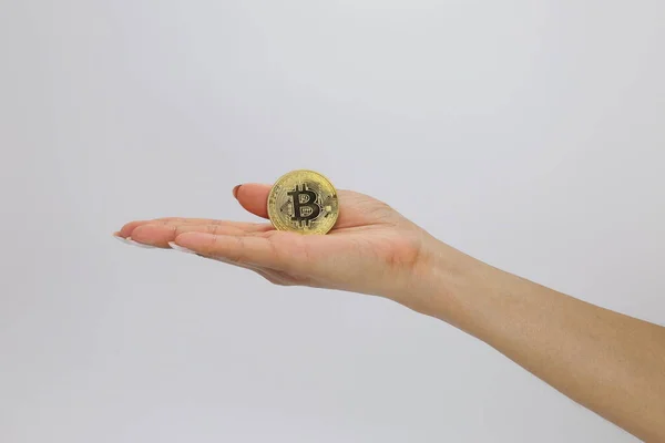 Cryptocurrency bitcoin gold medals. A person holds a cryptocurrency symbol in his hand-electronic virtual money for web banking and international network payments
