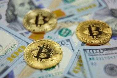 Altın Bitcoin ve dolar geçmişi. 100 dolarlık banknotların üzerinde Bitcoin 'in sembolik sikkeleri. Bitcoin 'i bir dolara değişelim..