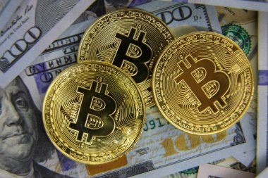 Altın Bitcoin yüz dolar faturaları üzerinde. Yakın çekim, makro çekim.