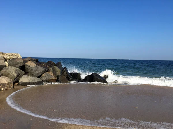 Okyanus suyu göz kamaştırıcı kayalara sıçrıyor.