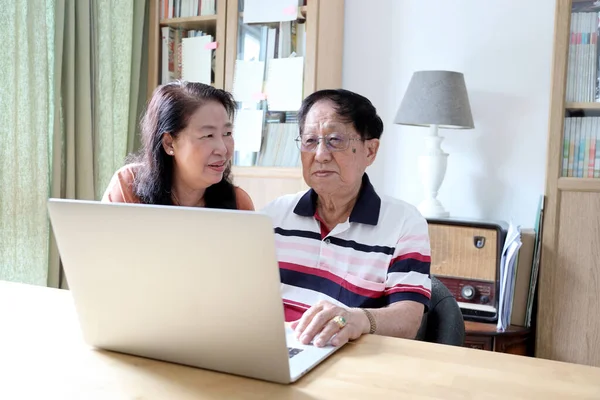 Evde dizüstü bilgisayar kullanan Asyalı çift..