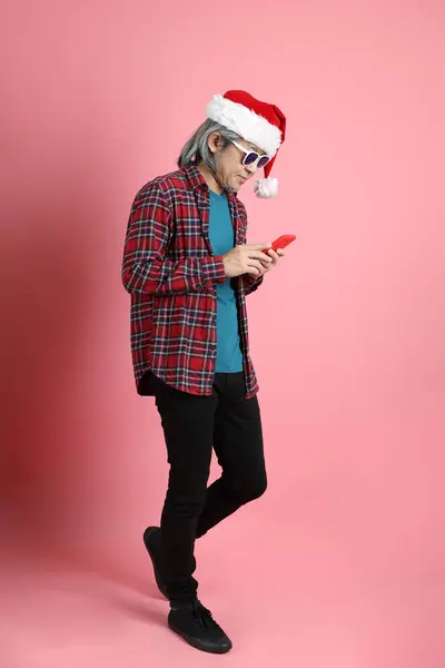 Старший Азіатський Чоловік Різдвяним Капелюхом Стоїть Рожевому Фоні — стокове фото