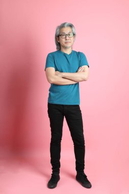 Pembe arka planda duran kıdemli Asyalı adam..