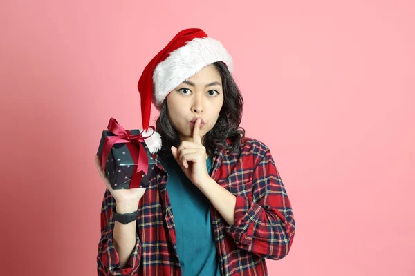 Pembe Arka Planda Duran Noel Baba Şapkalı Asyalı Kadın — Stok fotoğraf