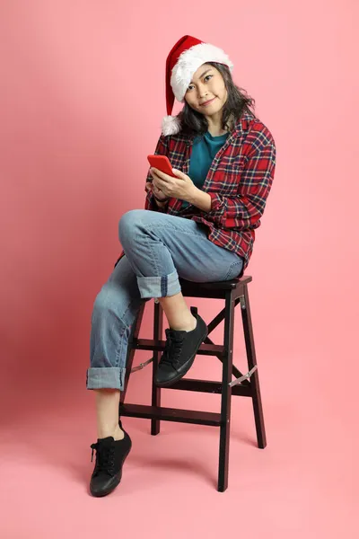 Die Asiatische Frau Mit Weihnachtsmütze Steht Auf Dem Rosa Hintergrund — Stockfoto