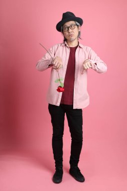 Pembe arka planda duran kıdemli Asyalı adam..