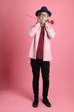 Pembe arka planda duran kıdemli Asyalı adam..