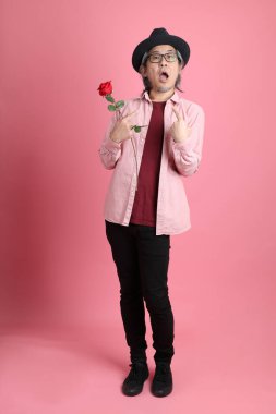 Pembe arka planda duran kıdemli Asyalı adam..