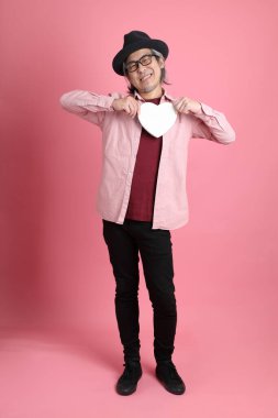 Pembe arka planda duran kıdemli Asyalı adam..