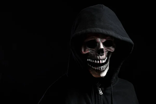 The skull mask with hood shirt in the dark background.