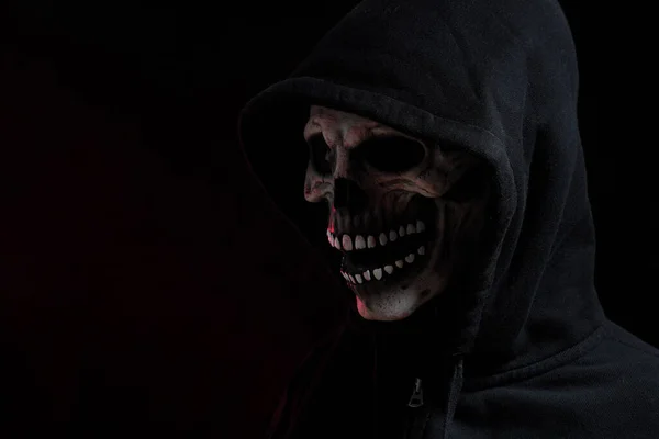 The skull mask with hood shirt in the dark background.