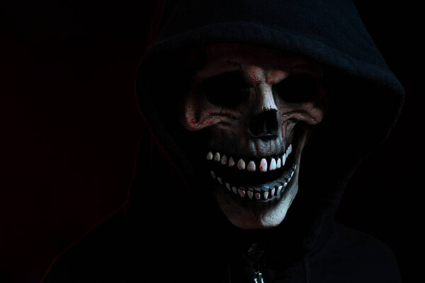 The skull mask with hood shirt in the dark background.
