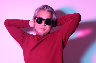 Jel renkli ışık fotoğrafçılığındaki havalı kıdemli Asyalı adam..