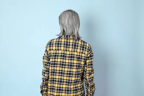 Mavi Arka Planda Duran Sarı Ekose Gömlekli Yaşlı Asyalı Adam — Stok fotoğraf
