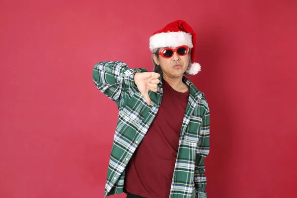 这位年长的亚洲男子穿着绿色格子呢衬衫 红底上戴着圣诞老人的帽子 — 图库照片