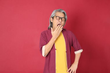 Kırmızı arka planda duran geleneksel Çin kıyafeti giyen kıdemli Asyalı adam..