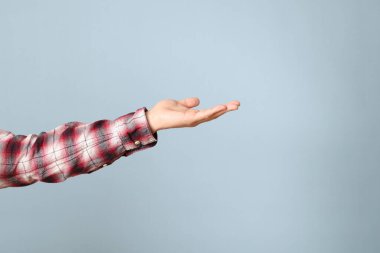 Mavi arka planda görünen ekose gömlekli Asyalı adam..